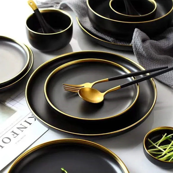"Close-up view of black porcelain plates and bowls with matching cutlery."