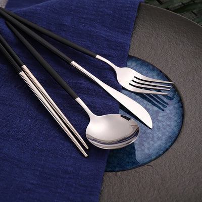 "Close-up view of black and gold stainless steel knives, forks, spoons, and chopsticks."