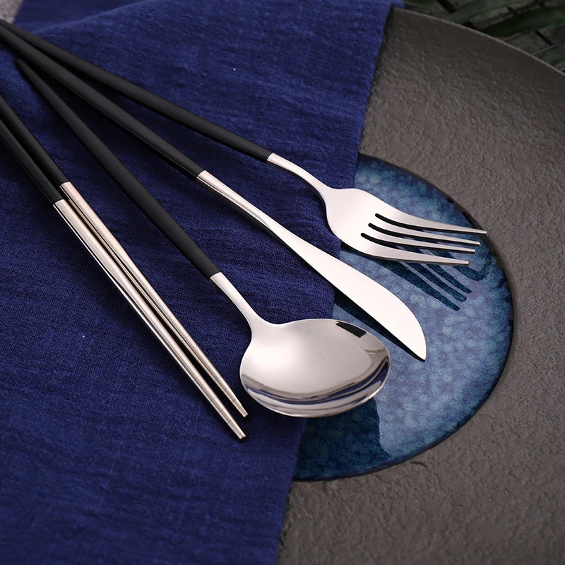 "Close-up view of black and gold stainless steel knives, forks, spoons, and chopsticks."