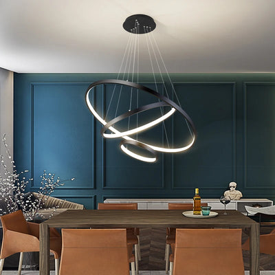 "Modern LED iron chandelier with three adjustable rings in a gold finish, illuminating a contemporary living room."