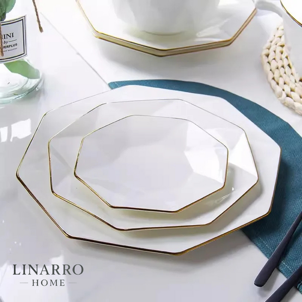Octagonal porcelain dinner plate with gold trim on white background